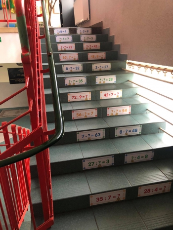 Naklejki z tabliczką mnożenia na stopniach schodów w szkole