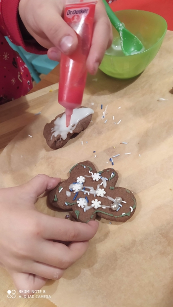 dziecko dekoruje świąteczne wypieki